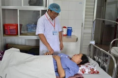 Bác sỹ thăm khám cho sản phụ sau phẫu thuật. (Ảnh: TTXVN phát)