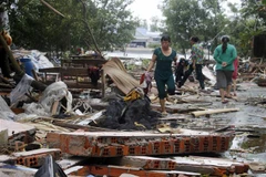 Người dân gom nhặt những gì còn sót lại từ căn nhà cũ đã bị sập ở xã Khánh Bình Tây, huyện Trần Văn Thời (Cà Mau). (Ảnh: Huỳnh Thế Anh/TTXVN)