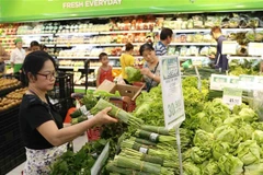 Người tiêu dùng mua sắm hàng hóa tại siêu thị. (Ảnh: Vũ Sinh/TTXVN)