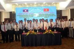 Trưởng đoàn đại biểu ba tỉnh Quảng Trị, Savannakhet, Salavan bắt tay đoàn kết, hữu nghị sau khi ký kết văn bản thỏa thuận hợp tác. (Ảnh: Trịnh Bang Nhiệm/TTXVN)