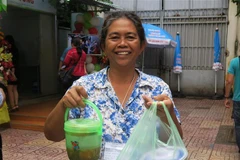 Người nhà bệnh nhân nhận suất ăn miễn phí từ Bếp yêu thương. (Ảnh: Đinh Hằng/TTXVN)