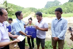 Bộ trưởng Bộ Lao động-Thương binh và Xã hội Đào Ngọc Dung tặng quà các gia đình bị thiệt hại nặng nề do ảnh hưởng mưa lũ tại bản Sa Ná, xã Na Mèo, huyện Quan Sơn có người thân bị chết, mất tích. (Ảnh: Anh Tuấn/TTXVN)