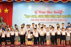 Trao học bổng cho học sinh, sinh viên vượt khó, học tốt. (Ảnh: K GỬIH/TTXVN)
