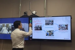 Đại diện Polycom trình diễn khả năng chia sẻ nội dung với bảng điện tử tương tác. (Ảnh: PV/Vietnam+)