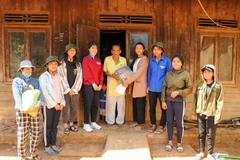 Nhi (mặc áo đỏ) cùng các bạn trong nhóm đến thăm một gia đình có hoàn cảnh khó khăn tại huyện Di Linh. (Ảnh: PV)