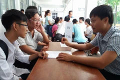 Thí sinh tìm hiểu thông tin xét tuyển đại học. (Ảnh: Phạm Mai/Vietnam+)