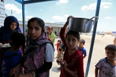 Trẻ em Iraq xếp hàng nhận lương thực cứu trợ tại khu vực Dora, ngoại ô thủ đô Baghdad ngày 31/5. (Nguồn: AFP/TTXVN)