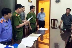 Công an đọc lệnh bắt tạm giam đối với ông Bùi Hoàng Hiền. (Ảnh: Đoàn Minh Huệ/Vietnam+)