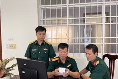 Thiếu tá Thiều Hữu Cường (ngồi giữa) với thiết bị IoT cảnh báo nguy cơ đột quỵ. (Ảnh: TTXVN phát)