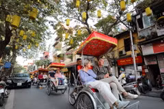 Du khách nước ngoài sử dụng xích lô dạo quanh phố phường, thưởng ngoạn nét đẹp cổ kính của Hà Nội. (Ảnh: Thanh Tùng/TTXVN)