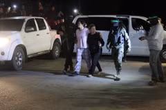 Các tay súng Hamas bàn giao nhóm con tin người Israel cho Ủy ban Chữ thập Đỏ Quốc tế tại Rafah, miền Nam Dải Gaza, ngày 28/11/2023. (Ảnh: AFP/TTXVN)