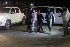 Các tay súng Hamas bàn giao nhóm con tin người Israel cho Ủy ban Chữ thập Đỏ Quốc tế tại Rafah, miền Nam Dải Gaza, ngày 28/11/2023. (Ảnh: AFP/TTXVN)