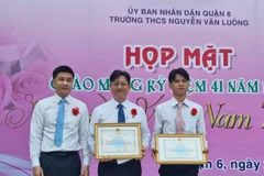 Lãnh đạo Bảo hiểm xã hội Thành phố Hồ Chí Minh tuyên dương, khen thưởng thầy hiệu trưởng và tập thể giáo viên Trường THCS Nguyễn Văn Luông, Quận 6. (Ảnh: TTXVN phát)