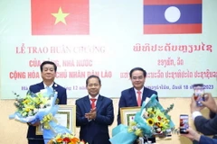 Ông Khamlay Sipraseuth, Uỷ viên Trung ương Đảng, Phó Chủ tịch thường trực Uỷ ban Trung ương Mặt trận Lào Xây dựng Đất nước trao tặng Huân chương Itxala (Tự do) hạng III cho Thứ trưởng Bộ Nội vụ Vũ Chiến Thắng (bên phải) và nguyên Thứ trưởng, nguyên Phó Chủ nhiệm Ủy ban Dân tộc Hoàng Xuân Lương (bên trái). (Ảnh: Văn Điệp/TTXVN)