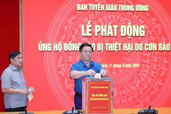 Đồng chí Nguyễn Trọng Nghĩa, Ủy viên Bộ Chính trị, Bí thư Trung ương Đảng, Trưởng Ban Tuyên giáo Trung ương ủng hộ đồng bào bị thiệt hại do cơn bão số 3. (Ảnh: Phương Hoa/TTXVN)