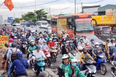 Người dân khó khăn khi di chuyển trên Quốc lộ 1, đoạn từ nút giao Nguyễn Văn Linh đến Nguyễn Hữu Trí. (Ảnh: Mạnh Linh/TTXVN)