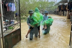 Lực lượng chức năng giúp người dân Chương Mỹ (Hà Nội) di chuyển đến những nơi an toàn. (Ảnh: TTXVN phát)