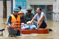 Lực lượng quân đội giúp người dân di chuyển và tiếp tế nhu yếu phẩm. (Ảnh: Thanh Tùng/TTXVN)