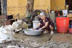 Người dân sinh sống trên 2 tuyến phố Thanh Niên và Trần Hưng Đạo, thành phố Yên Bái, dần trở lại cuộc sống thường nhật cho dù đường vẫn còn chưa hết ngập, chiều ngày 14/9. (Ảnh: Tuấn Anh/TTXVN)
