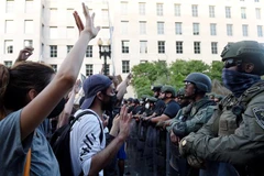 Cảnh sát được triển khai để ngăn người biểu tình quá khích trong cuộc tuần hành phản đối hành động của cảnh sát dẫn đến cái chết của người da màu George Floyd, tại Washington, DC. (Ảnh: AFP/TTXVN)