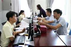 Cán bộ tiếp nhận hồ sơ, giải quyết thủ tục hành chính. (Ảnh: Việt Hoàng/TTXVN)