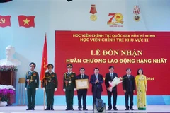 Bí thư Trung ương Đảng, Chủ tịch Hội đồng Lý luận Trung ương, Giám đốc Học viện Chính trị quốc gia Hồ Chí Minh Nguyễn Xuân Thắng trao Huân chương Lao động hạng Nhất của Chủ tịch nước tặng Học viện Chính trị khu vực II. (Ảnh: Thu Hoài/TTXVN)