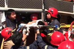 Lực lượng chức năng tham gia giải cứu 3 nạn nhân. (Ảnh: Trịnh Duy Hưng/TTXVN)