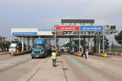 Lực lượng chức năng hướng người điều khiển phương tiện đi đúng làn đường. (Ảnh: Nguyên Lý/TTXVN)