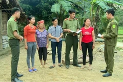 Công an huyện Lâm Bình tuyên truyền pháp luật cho chị Lý Thị Lịu (thứ 2 từ phải sang) và người dân thôn Khau Cau, xã Phúc Yên, huyện Lâm Bình, tỉnh Tuyên Quang. (Ảnh: Quang Đán/TTXVN)