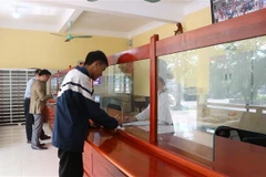 Tại bộ phận một cửa, khách đến giao dịch, học sinh đến nộp học phí đều tiết kiệm được thời gian, thuận lợi và nhanh chóng hơn. (Ảnh: Hoàng Ngà/TTXVN)