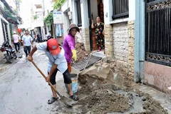 Người dân hẻm 62, Quận 3 vui vẻ, đồng lòng hiến đất mở rộng hẻm. (Ảnh: Thanh Vũ/TTXVN)