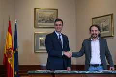 Thủ tướng tạm quyền Tây Ban Nha Pedro Sanchez (trái) và lãnh đạo đảng Unidas Podemos, ông Pablo Iglesias sau lễ ký thỏa thuận sơ bộ về thành lập Chính phủ liên minh tại thủ đô Madrid. (Ảnh: AFP/TTXVN)