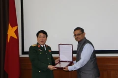 Lãnh đạo hai bên trao biểu tượng. (Ảnh: Huy Bình-Minh Luyến/Vietnam+)