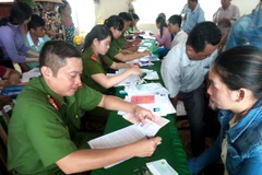 Người dân đến làm thủ tục cấp đổi miễn phí Giấy chứng minh dân nhân. (Ảnh: Huỳnh Sử/TTXVN)