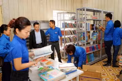 Đoàn viên thanh niên TTXVN chuyển sách lên giá tại thư viện trường Phổ thông Dân tộc bán trú Tiểu học và THCS Phình Hồ. (Ảnh: Thành Đạt/TTXVN)