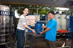 Những can nước sạch đầu tiên dành tặng bà con. (Ảnh: CTV/Vietnam+)