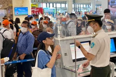 Nhân viên an ninh hàng không kiểm tra thông tin hành khách trước khi vào điểm soi chiếu tại một sân bay. (Ảnh: CTV/Vietnam+)
