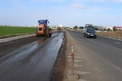 Đơn vị thi công thực hiện dự án cải tạo, nâng cấp một tuyến Quốc lộ. (Ảnh: Phạm Cường/TTXVN)