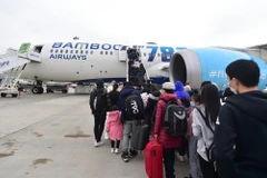 Gần 300 người Việt Nam tại Ukraine đã lên máy bay của hãng hàng không Bamboo Airways tại sân bay Warsaw (Ba Lan) để trở về nước. (Ảnh: CTV/Vietnam+)