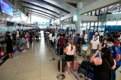 Hành khách xếp hàng dài làm thủ tục để lên chuyến bay. (Ảnh: CTV/Vietnam+)