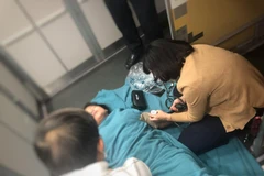 Bác sỹ sơ cứu bệnh nhân trên chuyến bay của Vietnam Airlines (Ảnh: CTV/Vietnam+)