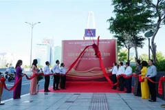 Các đại biểu thực hiện nghi thức gắn biển tên cầu Ba Son. (Ảnh: Thu Hương/TTXVN)