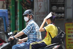 Người phải di chuyển dưới nắng nóng, nền nhiệt cao ngoài trời dễ gây nên tình trạng sốc nhiệt, mất nước, kiệt sức... (Ảnh: Hoàng Hiếu/TTXVN)