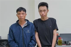 Đối tượng Chảo Chàn Khèn (trái) và Nguyễn Văn Thọ (phải) cùng tang vật. (Ảnh: TTXVN phát)