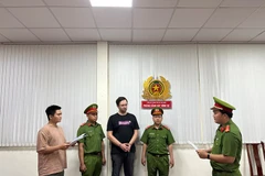 Lực lượng chức năng tống đạt quyết định tố tụng đối với đối tượng Aigars Plivčs. (Ảnh: Công an Thành phố Hồ Chí Minh cung cấp)