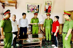 Cơ quan Cảnh sát điều tra Công an tỉnh Thanh Hóa thi hành Lệnh bắt tạm giam đối với Nguyễn Thị Minh (áo đỏ). (Ảnh: Công an cung cấp)