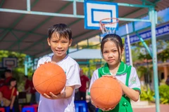 Em Nguyễn Uyển Vy cùng bạn hào hứng với những trái bóng mới do Báo Điện tử VietnamPlus trao tặng. (Ảnh: Minh Sơn/Vietnam+)