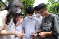Thí sinh xem lại bài sau buổi thi. (Ảnh: Hoài Nam/Vietnam+)
