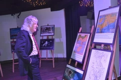 Bạn bè Pháp xem bản đồ tại Triển lãm và tọa đàm về chủ đề Biển Đông tại Pháp. (Ảnh: Bích Hà/TTXVN)