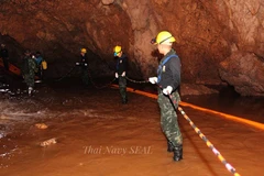 Lực lượng cứu hộ chuyển thiết bị vào hang Tham Luang để giải cứu đội bóng thiếu niên ngày 6/7. (Nguồn: EPA-EFE/TTXVN)